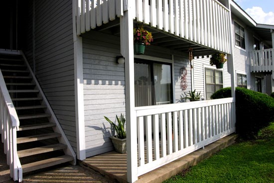 Pier Landing Apartments up close view at white fenced porch and a staircase leading up to second floor